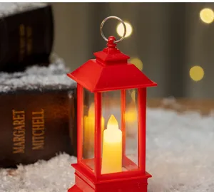 Detailed close-up of a red retro LED candle lantern placed on a decorative snow background.