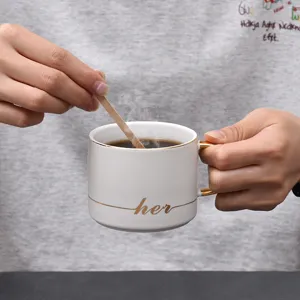 Keramische koffiekop met houten roerstaaf, elegante witte kop met gouden rand voor dagelijks gebruik.