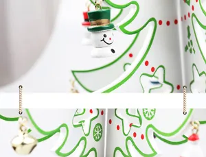 Close-up of white wooden Christmas tree with snowman ornaments and green snowflakes