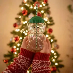 Joli verre tasse avec couvercle bonnet tricoté vert et paille pour boissons de fête.