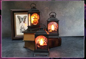 Dettaglio di tre lanterne LED vintage di Halloween con disegni luminosi di zucche e pipistrelli
