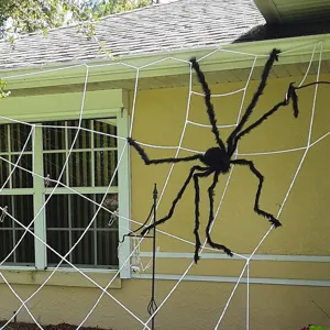 Γιγαντιαία μαύρη λούτρινη αράχνη Halloween διακόσμηση σε μεγάλο λευκό ιστό αράχνης.
