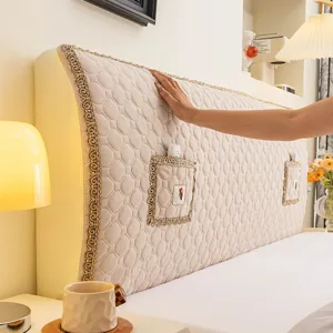 Detailed view of the quilted stretch fabric bedhead cover with elegant lace trim and storage pocket.
