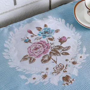 Close-up detail of blue pastoral style fabric microwave dust cover with floral pattern.