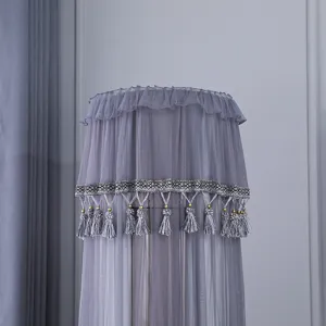 Vista dettagliata della copertura per condizionatore in pizzo grigio con eleganti frange.