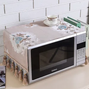 Vintage floral microwave dust cover with delicate fringe detail in home pastoral kitchen setting.