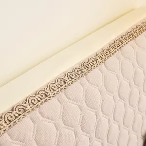 Close-up detail of quilted elastic fabric headboard cover with elegant lace trim.