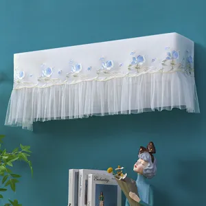Detailed shot of white lace air conditioner dust cover with blue floral embroidery and ruffles.