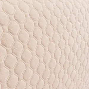 Close-up detail of beige quilted headboard cover fabric showcasing soft geometric hexagon texture.