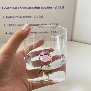 Primer plano detallado de un vaso de vidrio transparente con una rosa rosa 3D dentro para bebidas.