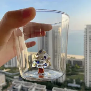 Vista dettagliata del bicchiere trasparente con albero di Natale 3D unico all'interno, regalo