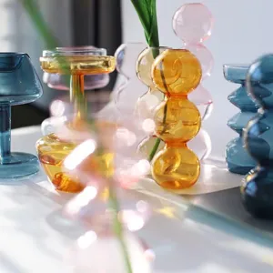 Detailed view of colorful transparent glass bubble vases in artistic ins style home decor.