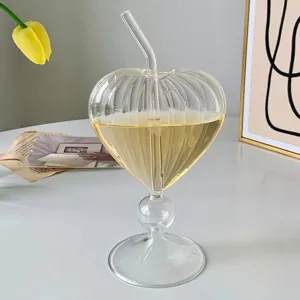 Clear glass heart-shaped cocktail cup detail, elegant ribbed design with glass straw.