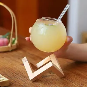 Spherical glass cup with straw and wooden stand, moon design for drinks and coffee.