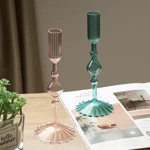 Detail shot of creative minimalist glass candle holders in pink and green for elegant decor.
