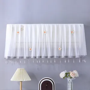 Housse anti-poussière blanche en dentelle pour climatiseur avec détails floraux.