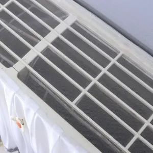 Déflecteur de vent pour climatiseur mural avec écran en maille et jupe plissée décorative.