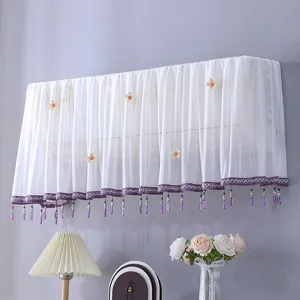 Housse de climatiseur en dentelle blanche avec decor floral et franges de perles pour unite murale.