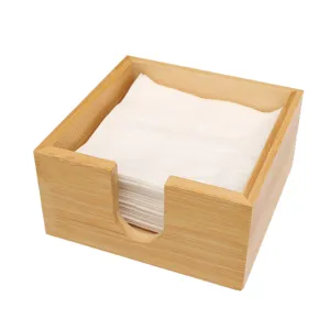 Servilletero cuadrado de bambú para mesa, acabado en madera natural con servilletas blancas.