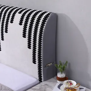 Dettaglio della copertura per testata letto in ciniglia con motivo bianco nero e tasca.