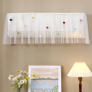 Detailed view of white mesh air conditioner dust cover with colorful pom-pom decorations.