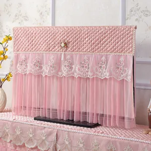 Vista dettagliata della copertura TV in velluto trapuntato rosa e pizzo, design sospeso.
