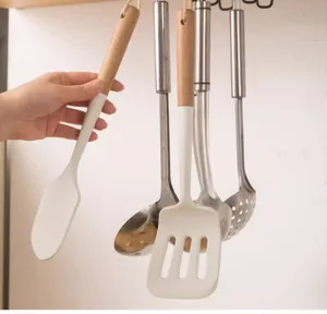 Close-up of white silicone spatula hanging on under-cabinet kitchen utensil hook rack