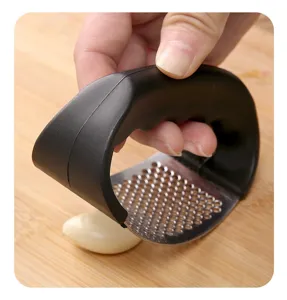 Schiacciaglio manuale in acciaio inossidabile con manico nero ergonomico per tritare l'aglio.