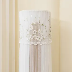 Primo piano di una copertura per condizionatore verticale in rete con ricamo floreale elegante.