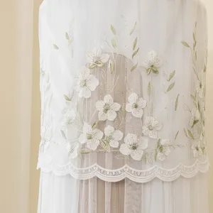 Dettaglio copertura per condizionatore rotonda verticale, rete bianca elegante con ricamo floreale.