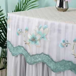 Detalle de funda para lavadora de encaje, bordado floral y elegante borde festoneado.