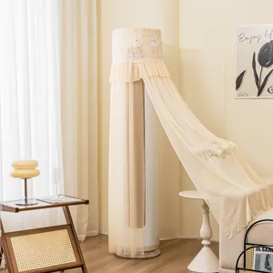 Vista detallada de la funda de aire acondicionado cilíndrica de encaje beige con bordado.