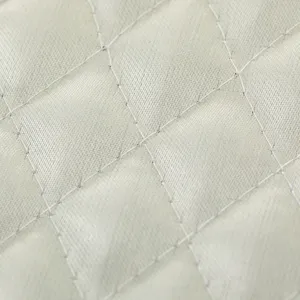 Primer plano detallado del tejido acolchado para funda de polvo con patron de rombos.