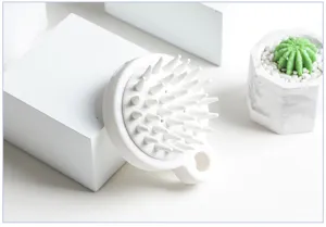 Vue détaillée de la brosse de massage du cuir chevelu en silicone blanc, poils souples.
