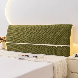 Detailed close-up view of the green quilted elastic headboard cover with decor straps.