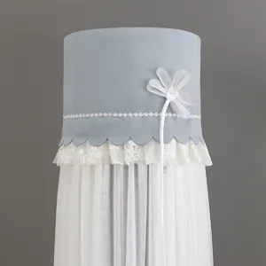 Close-up detail of light blue cylinder air conditioner cover with white lace trim and floral accent.
