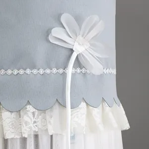 Close-up detail of light blue vertical air conditioner cover featuring elegant lace and floral trim.