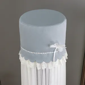 Light blue cylindrical vertical air conditioner cover detail featuring white lace and flower decor.