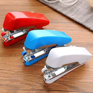 Portable mini handheld sewing machine detail showing red, blue and white compact craft tools.
