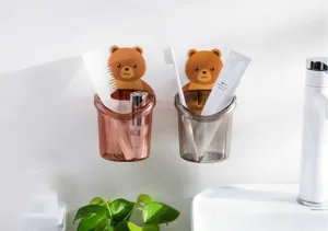Dettaglio del porta spazzolini da muro a forma di orsetto con bicchiere trasparente.