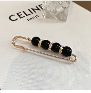 Spilla di sicurezza dorata elegante con perline nere e strass per stringere la vita.