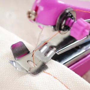 Portable mini handheld sewing machine for quick home cloth repairing and DIY crafting.