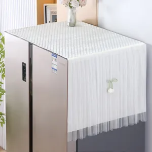 Detailed view of white refrigerator cover cloth featuring quilted top and lace fringe.