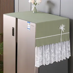 Detailansicht der grünen Stoff-Kühlschrankstaubschutzhaube mit weißer Spitzen- und Blumendeko.