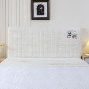 Detail shot of thickened quilted headboard cover in white with cute puppy embroidery design.
