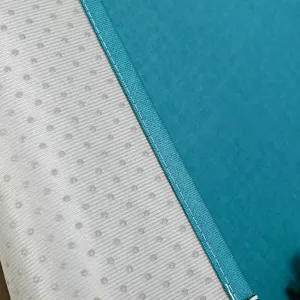 Gros plan du tissu de housse anti-poussière, coutures nettes et dos antidérapant.