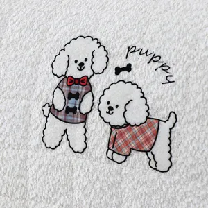 Detailed shot of thick plush headboard cover fabric with cute embroidered poodles pattern.