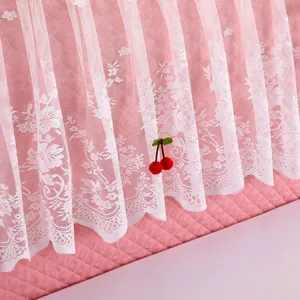 Pink quilted headboard cover with delicate white lace overlay and sweet cherry charm detail.
