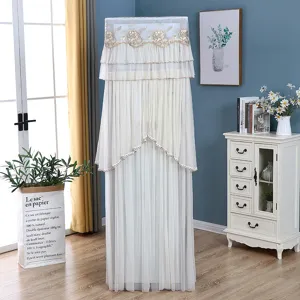 Dettaglio copertura climatizzatore verticale, elegante pizzo bianco con ricamo dorato.