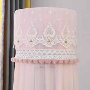 Primo piano della copertura verticale rosa per condizionatore con pizzo bianco e pon pon eleganti.